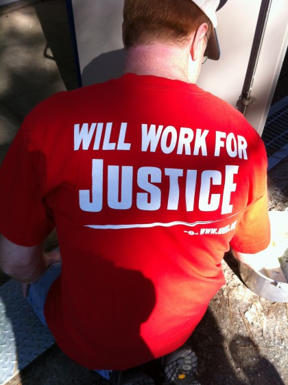 Helping hand's T-Shirt reads "Will work for Justice"